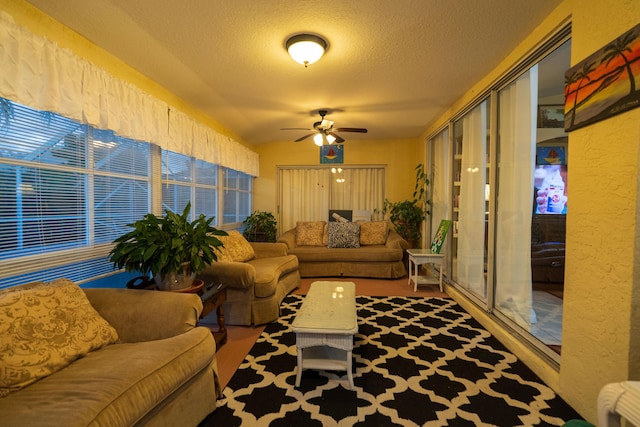 living room with ceiling fan and a textured ceiling