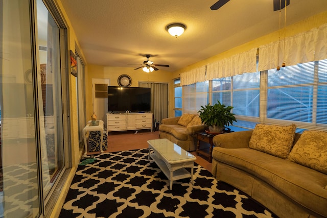 living room featuring a textured ceiling, ceiling fan, and carpet flooring