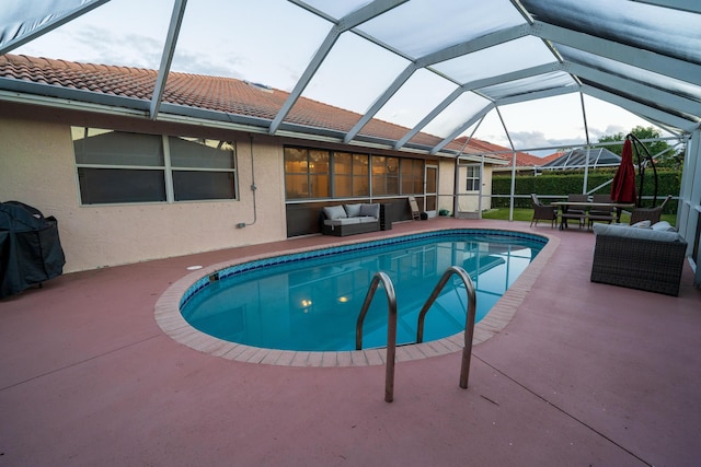 view of pool with a patio, an outdoor hangout area, and glass enclosure