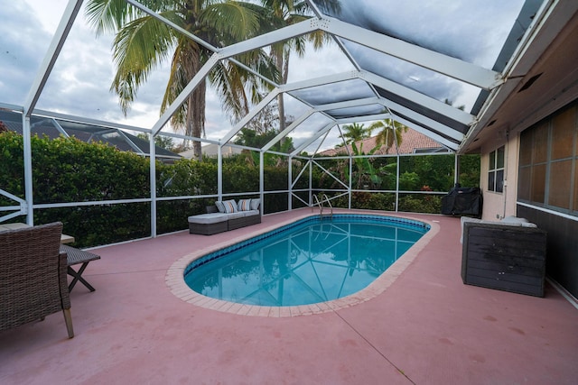 view of swimming pool with outdoor lounge area, a grill, a lanai, and a patio