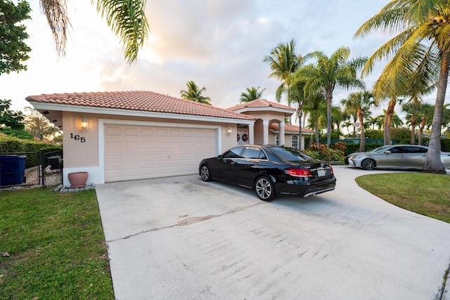 mediterranean / spanish house with a garage and a yard