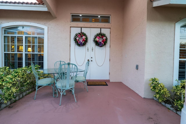 view of exterior entry featuring a patio