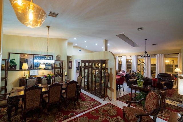 dining area with lofted ceiling, an inviting chandelier, and light tile patterned flooring