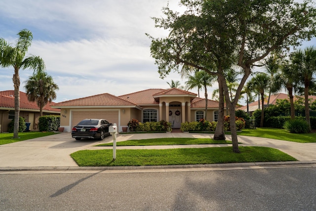 165 Cypress Trce, Royal Palm Beach, FL 33411 - mediterranean / spanish-style home featuring stucco siding, driveway, a garage, a front lawn, and a tile roof
