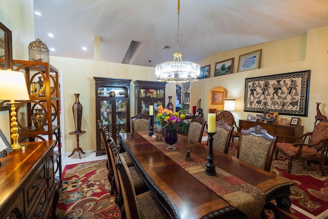 dining room featuring a notable chandelier and vaulted ceiling