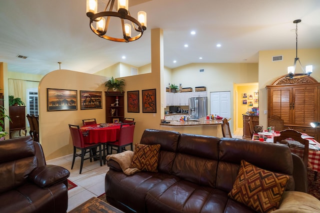 living room featuring an inviting chandelier, lofted ceiling, and light tile patterned floors