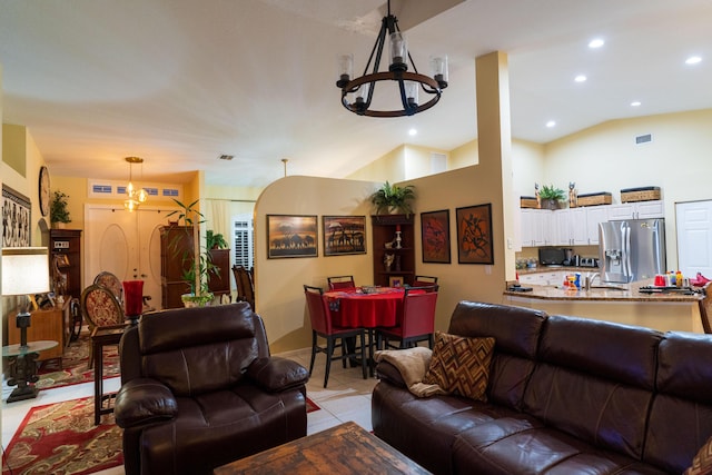 living room featuring lofted ceiling, a notable chandelier, and light tile patterned flooring