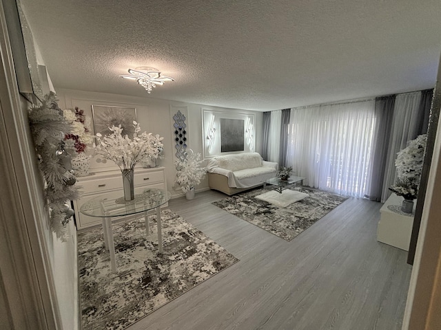 unfurnished living room featuring hardwood / wood-style floors and a textured ceiling