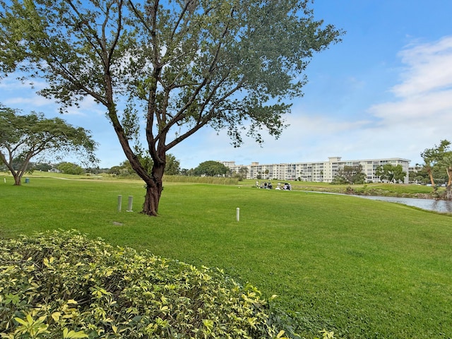 view of property's community with a lawn and a water view