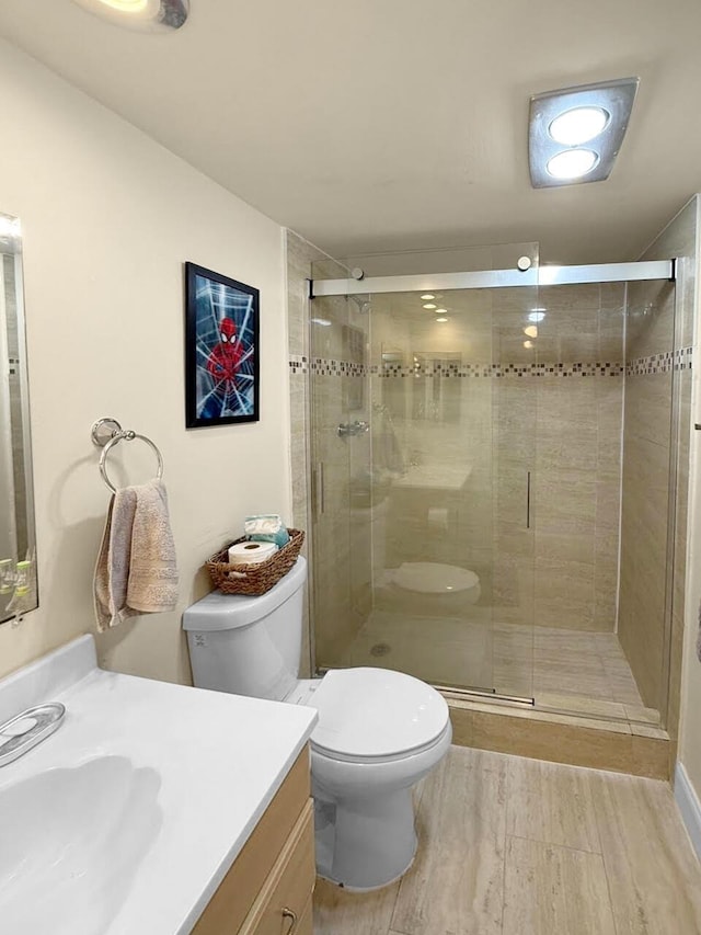 bathroom with vanity, hardwood / wood-style flooring, toilet, and walk in shower