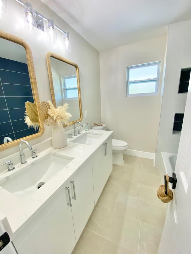 bathroom featuring vanity, a bath, tile patterned floors, and toilet