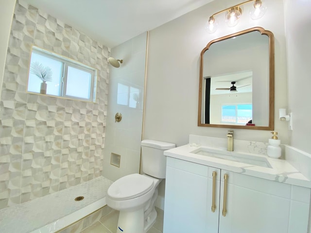 bathroom featuring a tile shower, vanity, and toilet