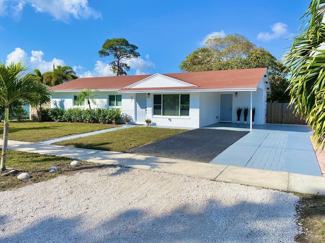 ranch-style house with a carport and a front lawn