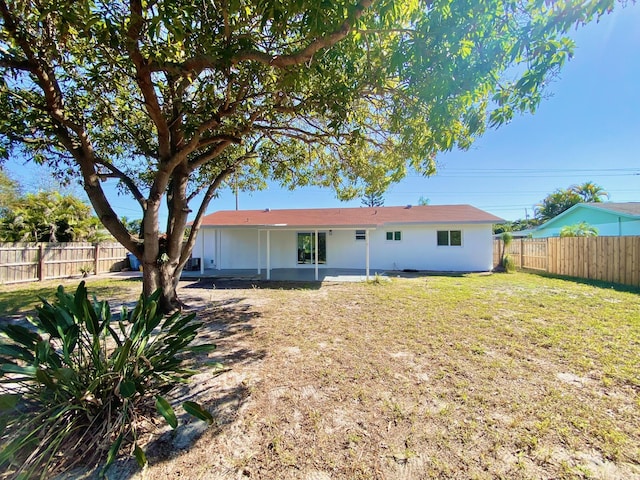 rear view of property featuring a yard