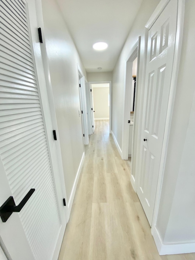 hallway with light hardwood / wood-style floors