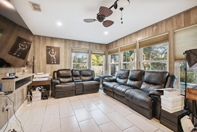 living room featuring ceiling fan and wood walls