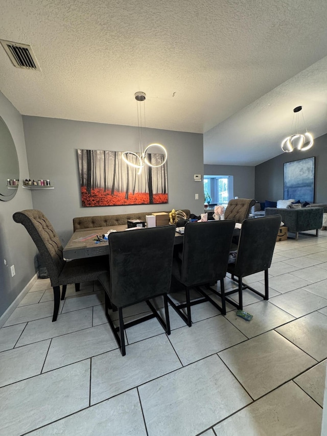 dining area with a textured ceiling and a chandelier