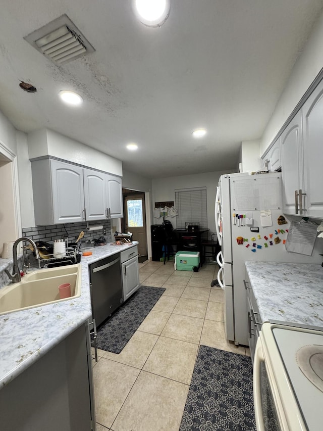 kitchen featuring sink, tasteful backsplash, range, light tile patterned floors, and dishwasher