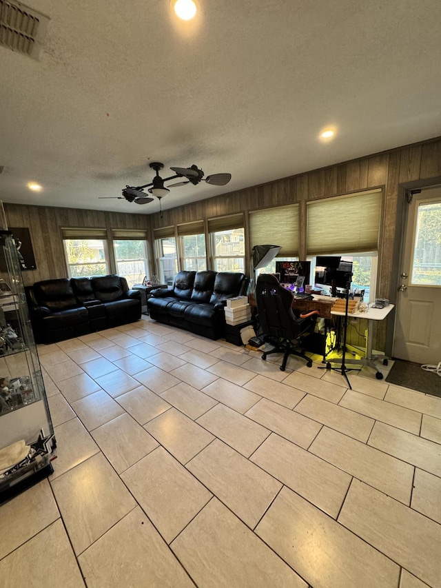 living room featuring a textured ceiling and wood walls