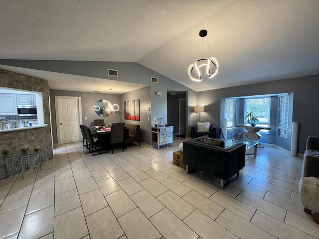 living room with a textured ceiling, vaulted ceiling, and a chandelier