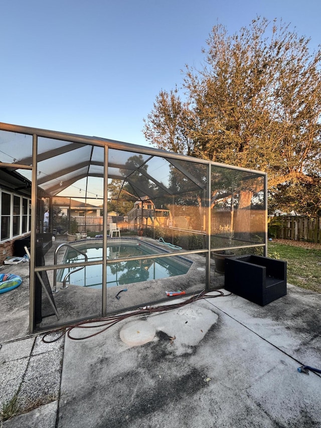 view of pool featuring glass enclosure and a patio area