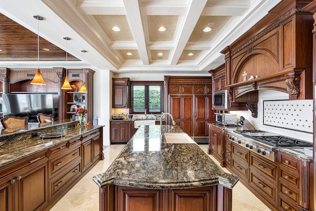 kitchen with sink, dark stone countertops, a large island with sink, appliances with stainless steel finishes, and pendant lighting