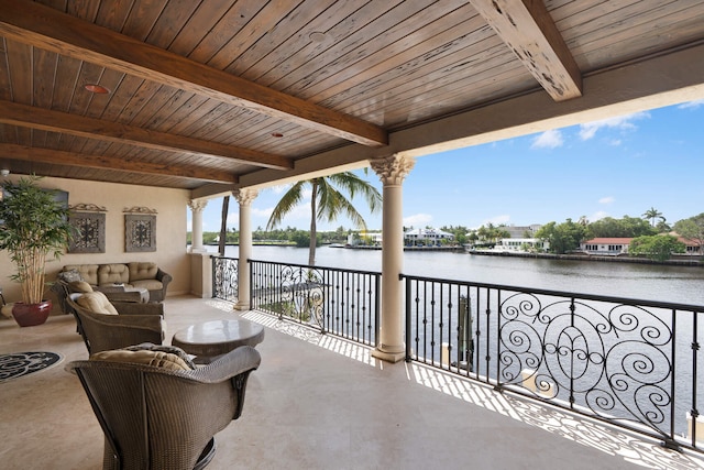 view of patio with a balcony and a water view