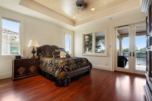 bedroom featuring french doors, access to outside, ornamental molding, a tray ceiling, and hardwood / wood-style floors