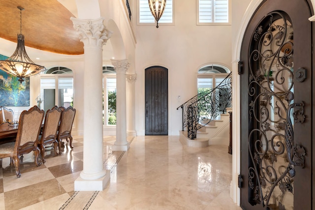 entryway with plenty of natural light, a high ceiling, and ornate columns