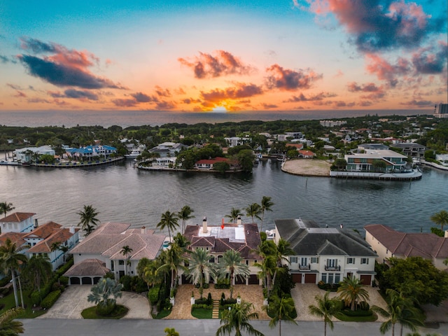 aerial view at dusk featuring a water view