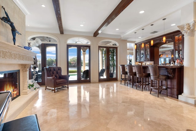 bar featuring french doors, beamed ceiling, a fireplace, and decorative light fixtures