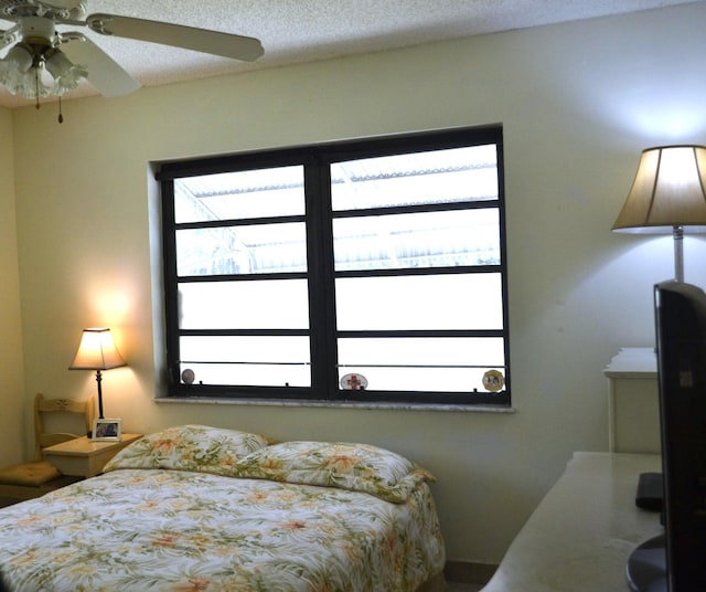 bedroom featuring ceiling fan and a textured ceiling