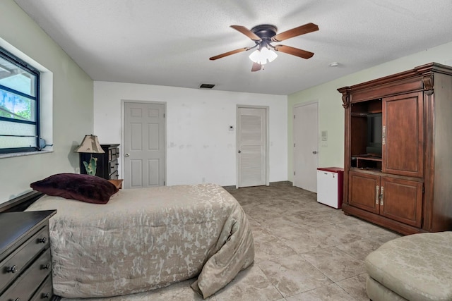 bedroom featuring refrigerator and a ceiling fan