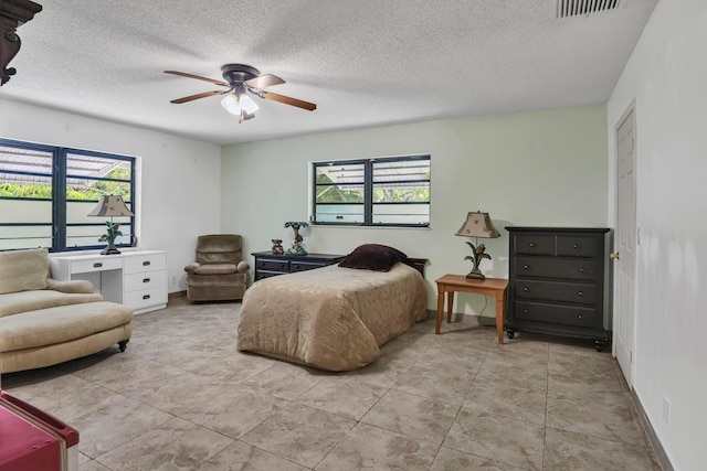 bedroom with multiple windows, a textured ceiling, ceiling fan, and baseboards