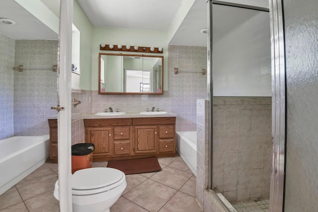 bathroom featuring tile walls, tile patterned floors, a shower stall, a tub to relax in, and toilet