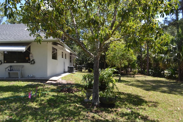 view of green lawn with cooling unit