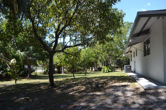 view of grassy yard featuring central AC