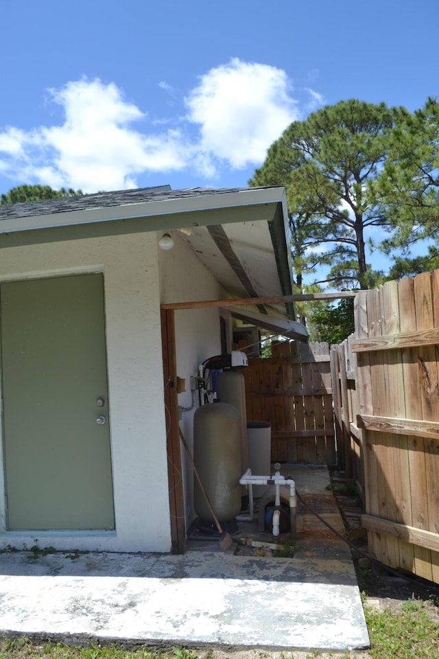 doorway to property featuring stucco siding and fence