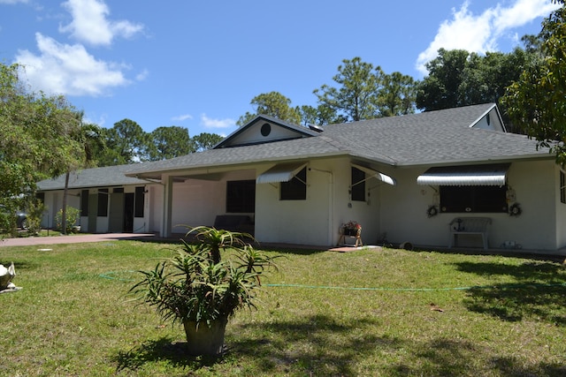 view of front facade featuring a garage, a front lawn, and roof with shingles