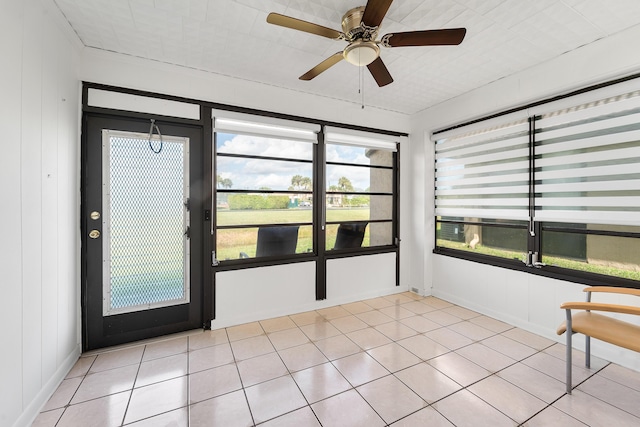 unfurnished sunroom with ceiling fan