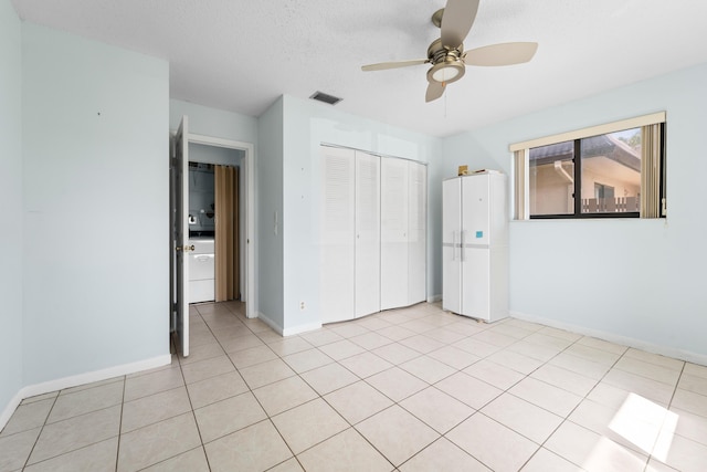 unfurnished bedroom featuring ceiling fan, light tile patterned floors, a textured ceiling, and a closet