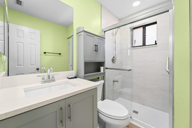 bathroom featuring vanity, toilet, and an enclosed shower