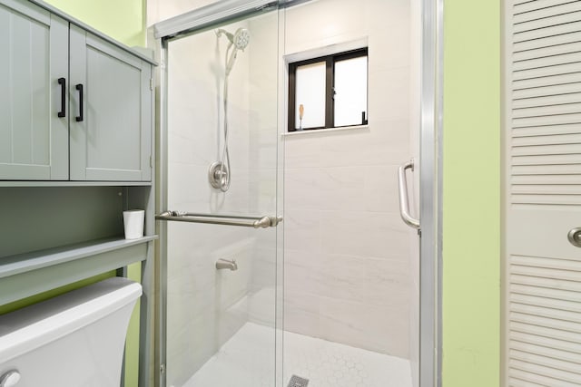 bathroom with toilet and a shower with door