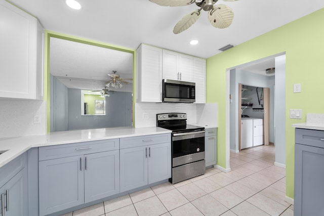 kitchen featuring ceiling fan, appliances with stainless steel finishes, white cabinets, and independent washer and dryer