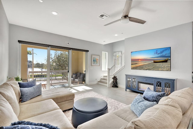 living area with stairway, wood finished floors, visible vents, recessed lighting, and ceiling fan