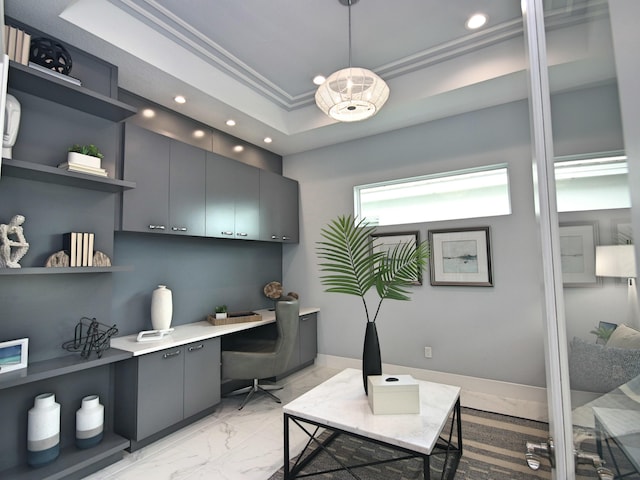 office with crown molding, built in desk, and a tray ceiling