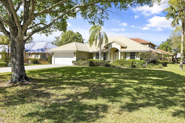 ranch-style home with a garage and a front lawn