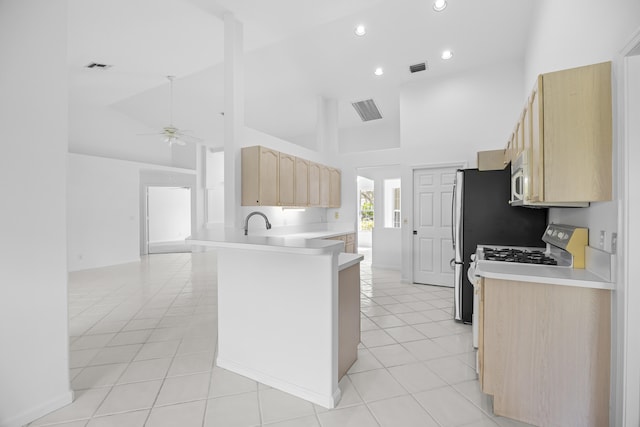 kitchen with light tile patterned flooring, high vaulted ceiling, ceiling fan, kitchen peninsula, and light brown cabinets