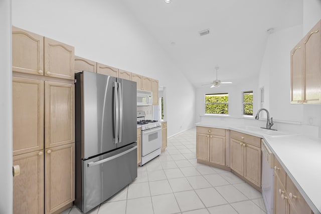 kitchen with sink, light tile patterned floors, ceiling fan, light brown cabinets, and white appliances