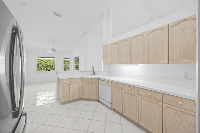 kitchen featuring stainless steel fridge, light brown cabinetry, sink, and white dishwasher